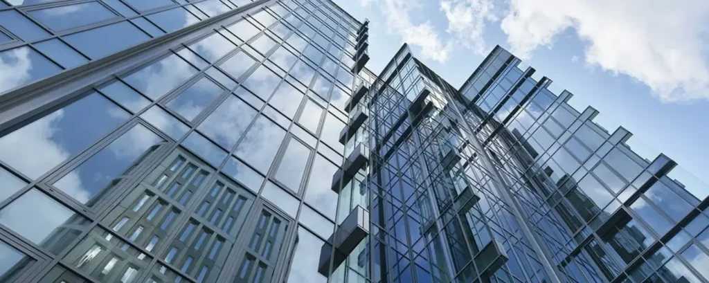 A close-up view of a high-rise building with a unitized curtain wall system, showing the seamless integration of glass and slim aluminium profiles